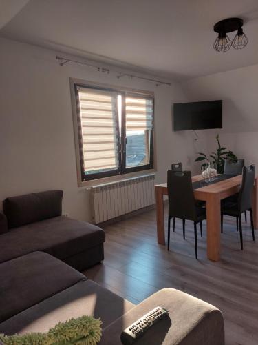 Zubrzyca DolnaZubrzycki Zakątek的客厅里有一张沙发和一张桌子。