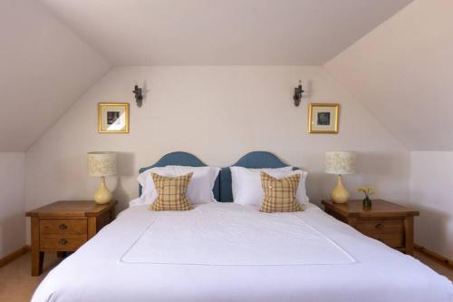 a bedroom with a large white bed with two lamps at Balvraid Steading - Awesome views, near Dornoch in Dornoch