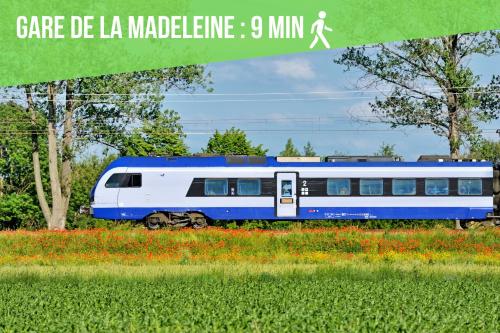 un train bleu et blanc dans un champ de fleurs dans l'établissement Le Flore - Les Demeures d'Adrien, à La Madeleine