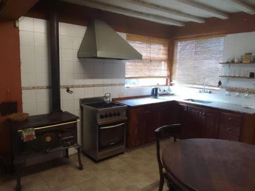 a kitchen with a stove and a table and a dining room at Casa Blanca in San Carlos de Bariloche