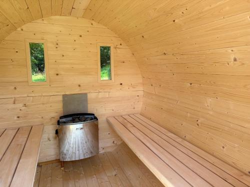 a wooden sauna with a trash can in the middle at Apartmán na sjezdovce in Sedloňov