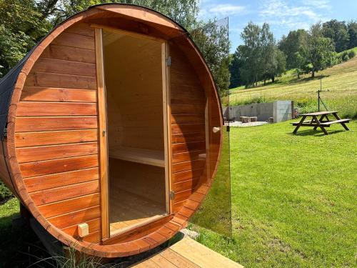 a wooden sauna in a field with a picnic table at Apartmán na sjezdovce in Sedloňov