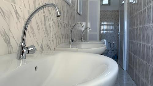 a white bathroom with a sink and a tub at Les HOTELS TALHAYA, NOUAKCHOTT in Nouakchott