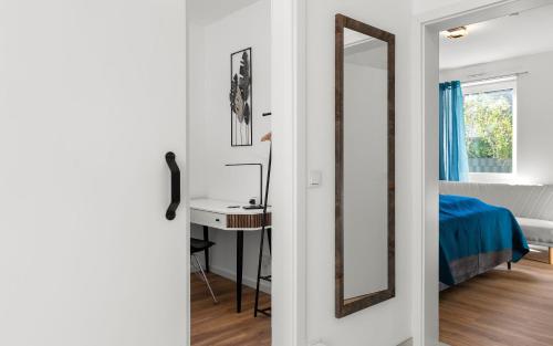 a bedroom with a mirror and a sink and a bed at Lit Living Deluxe Apartments Wörth - Parking - Box Spring - BBQ - Balcony in Wörth am Rhein