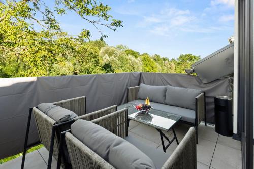 a patio with chairs and a table on a balcony at Lit Living Deluxe Apartments Wörth - Parking - Box Spring - BBQ - Balcony in Wörth am Rhein