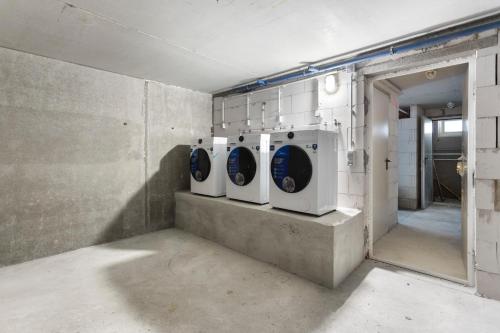 a bathroom with three washing machines in a room at Lit Living Deluxe Apartments Wörth - Parking - Box Spring - BBQ - Balcony in Wörth am Rhein
