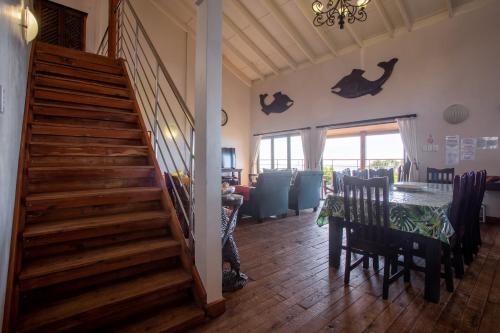 a living room with a staircase and a table and a dining room at Mar Azul 18 in Ponta Malongane