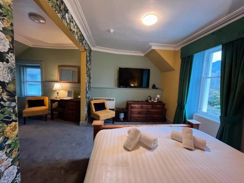 a hotel room with a bed and a tv and a bedroom at Achray House Restaurant with Rooms in Saint Fillans