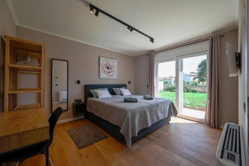 een slaapkamer met een bed en een groot raam bij Casa Ferata in Kanfanar