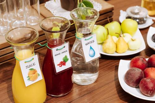 a table with two bottles of juice and a plate of apples at Gostišče Krivograd in Prevalje