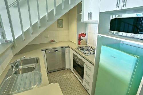 a kitchen with a sink and a stove top oven at 11 Whitecrest Great Ocean Road Resort - Ocean View in Apollo Bay