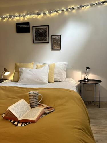 - une chambre avec un lit, un livre et une tasse de café dans l'établissement Grand triplex calme avec cour privée, à Paris