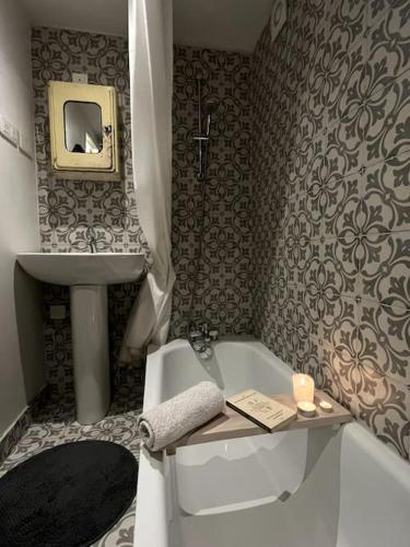 La salle de bains est pourvue d'une baignoire, d'un lavabo et d'une baignoire. dans l'établissement Grand triplex calme avec cour privée, à Paris