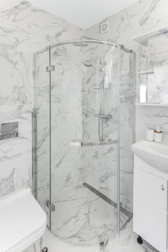 a bathroom with a shower with a toilet and a sink at Vila Naktižiedė in Šventoji