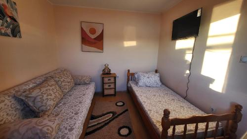 a small living room with a couch and a tv at SeaSide in Zelenika