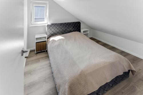 a bedroom with a large bed in a attic at Vila Naktižiedė in Šventoji