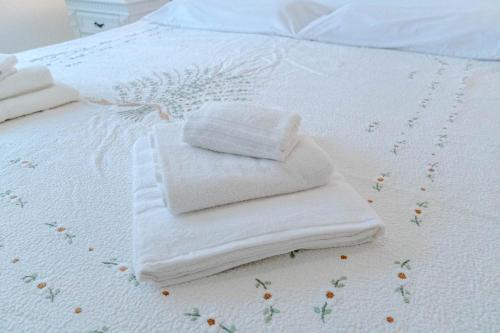 two towels on a bed with flowers on it at Lingotto District Functional Apartment in Turin