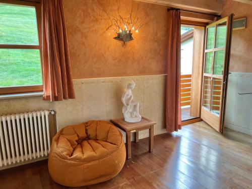 a living room with a chair and a ottoman at Appartamenti Forhotel in Livigno