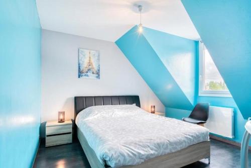 - une chambre avec des murs bleus, un lit et une chaise dans l'établissement Villa confortable à Ranville, piscine privée, à Ranville