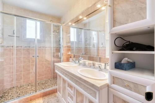 une salle de bain avec deux lavabos et une douche dans l'établissement Villa confortable à Ranville, piscine privée, à Ranville