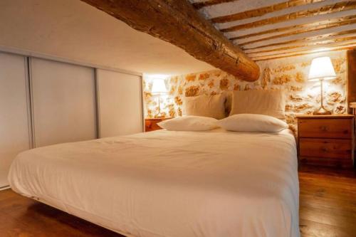 une chambre avec un grand lit blanc avec deux oreillers dans l'établissement Lovely air-conditioned studio - Vieil Antibes, à Antibes