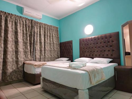two twin beds in a room with blue walls at Light House Lodge in Bela-Bela
