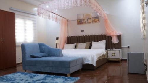 a bedroom with a bed and a blue chair at Les HOTELS TALHAYA, NOUAKCHOTT in Nouakchott