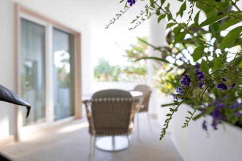 a table and chairs in a room with purple flowers at Maggiano Boutique Hotel in Peschici