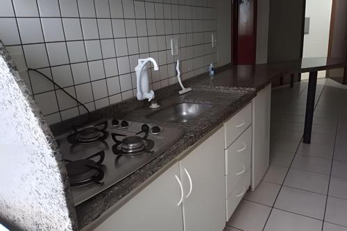 una cocina con estufa y fregadero en AP. 06 DO CANTINHO DO SOSSEGO, en Dourados