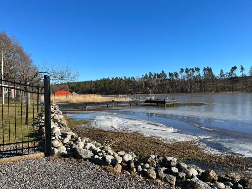 a fence next to a body of water at Beach Solsa in Nynäshamn