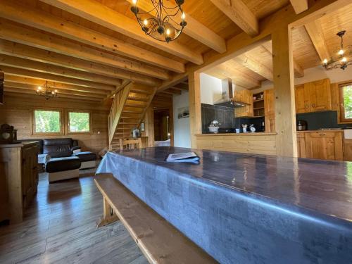 une grande cuisine et un salon avec un grand comptoir dans l'établissement Chalet Savoyard avec Jardin, Poêle à Bois et WIFI - FR-1-624-11, à Verchaix