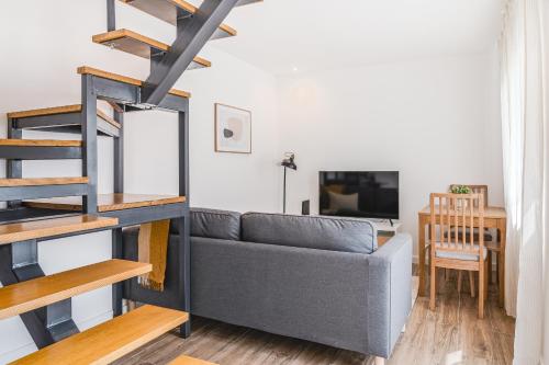 a living room with a gray couch and a table at Campolide Duplex Apartments in Lisbon
