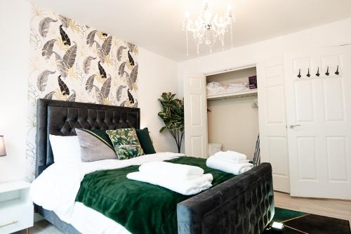 a bedroom with a large bed with a green blanket at Cozy Haven Flat in Milton Keynes