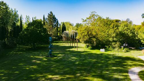 a park with trees and a blue pole in the grass at Bastide Rose in Le Thor