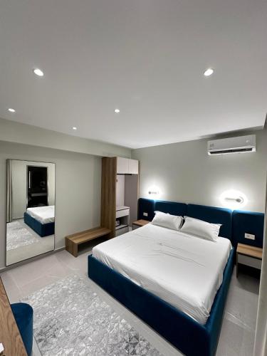 a bedroom with a large bed and a mirror at Art Rooms in Vlorë