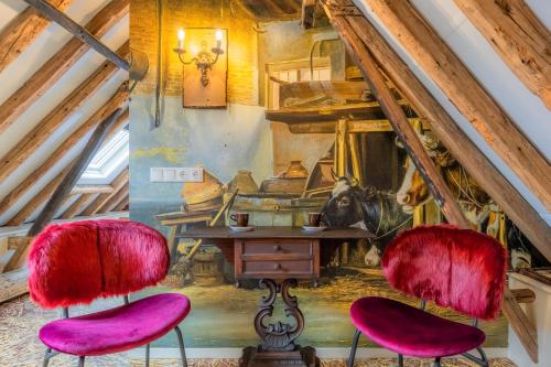 a room with a table and two pink chairs at Unieke Bed en Breakfast met historisch verhaal in Ferwert De K roon van Marijn in Ferwerd