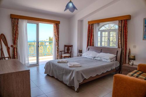 a bedroom with a bed and a large window at Villa Danae Coral Bay by Villa Plus in Peyia