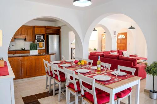 a dining room and living room with a table and chairs at Villa Danae Coral Bay by Villa Plus in Peyia