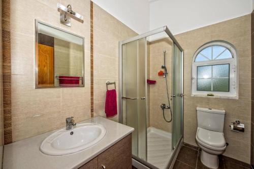 a bathroom with a sink and a toilet and a shower at Villa Danae Coral Bay by Villa Plus in Peyia