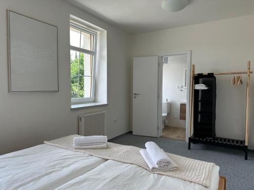 a white bedroom with two towels on a bed at Na sjezdovce in Sedloňov