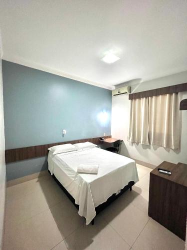 a bedroom with a bed and a blue wall at Veneza Plaza Hotel in Gurupi