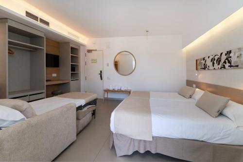a hotel room with two beds and a mirror at Bordoy Cosmopolitan in Playa de Palma