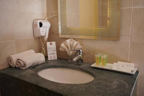 a bathroom counter with a sink and a phone at Petra Corner Hotel in Petra