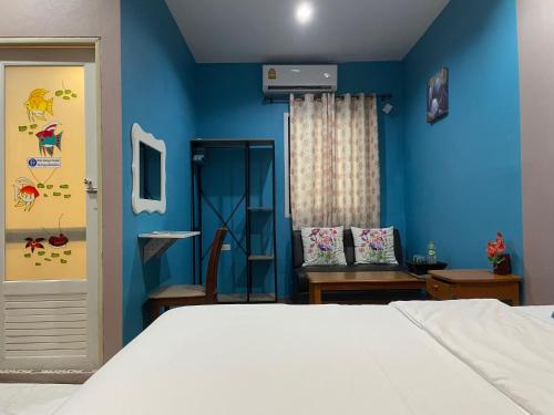 a bedroom with a bed and a blue wall at Nawaporn Place in Phuket Town