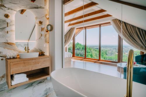 a bathroom with a tub and a large window at Villa Vukov Breg in Bogdanovec