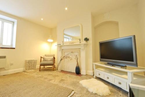 a living room with a flat screen tv and a fireplace at Spacious Boutique Apartment Clifton King Size Bed in Bristol