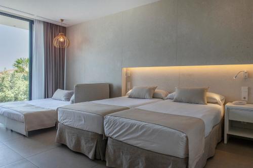 a hotel room with two beds and a window at Bordoy Cosmopolitan in Playa de Palma