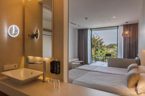 a hotel room with a bed and a mirror at Bordoy Cosmopolitan in Playa de Palma