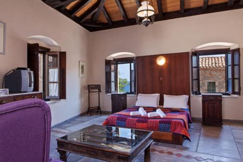 a living room with a bed and a tv at Byzantino Boutique Hotel in Monemvasia