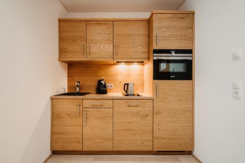 a kitchen with wooden cabinets and a stove at Alpina Wagrain in Wagrain